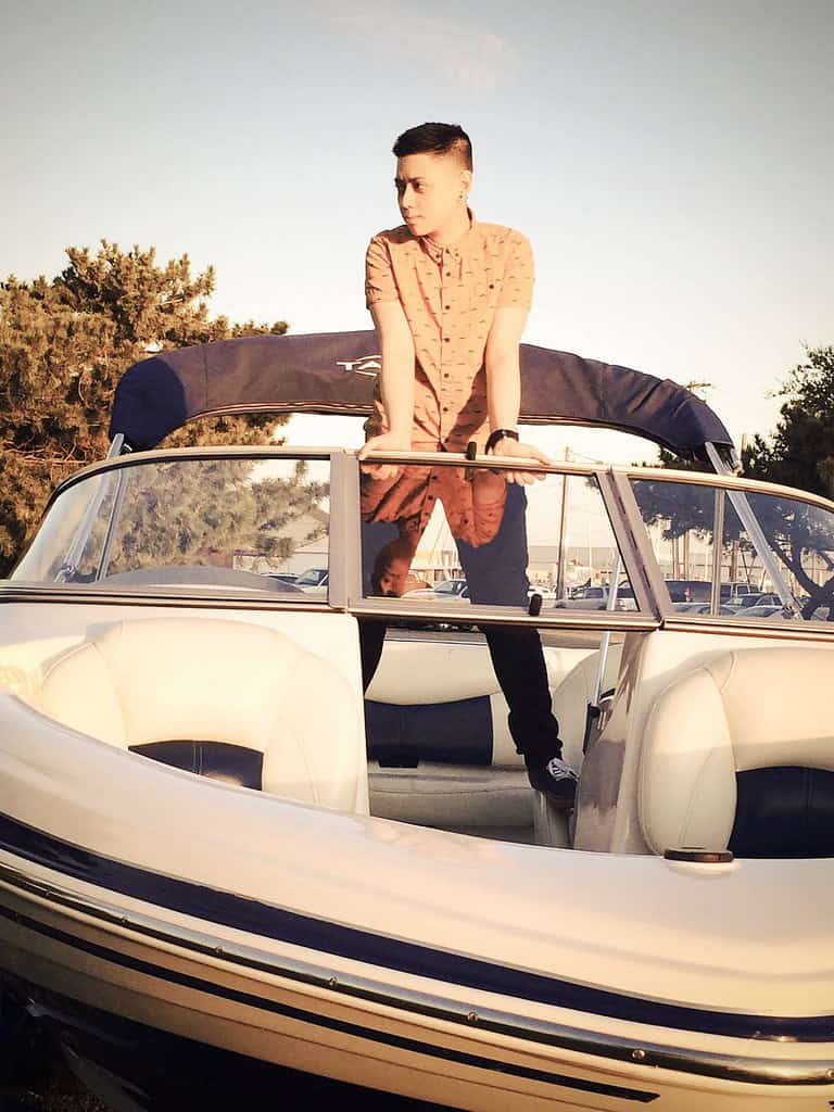 Person standing on a boat at sunset