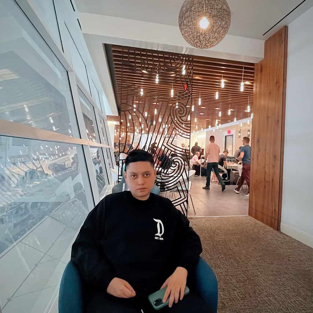 Person seated in lounge with modern design and ambiance.