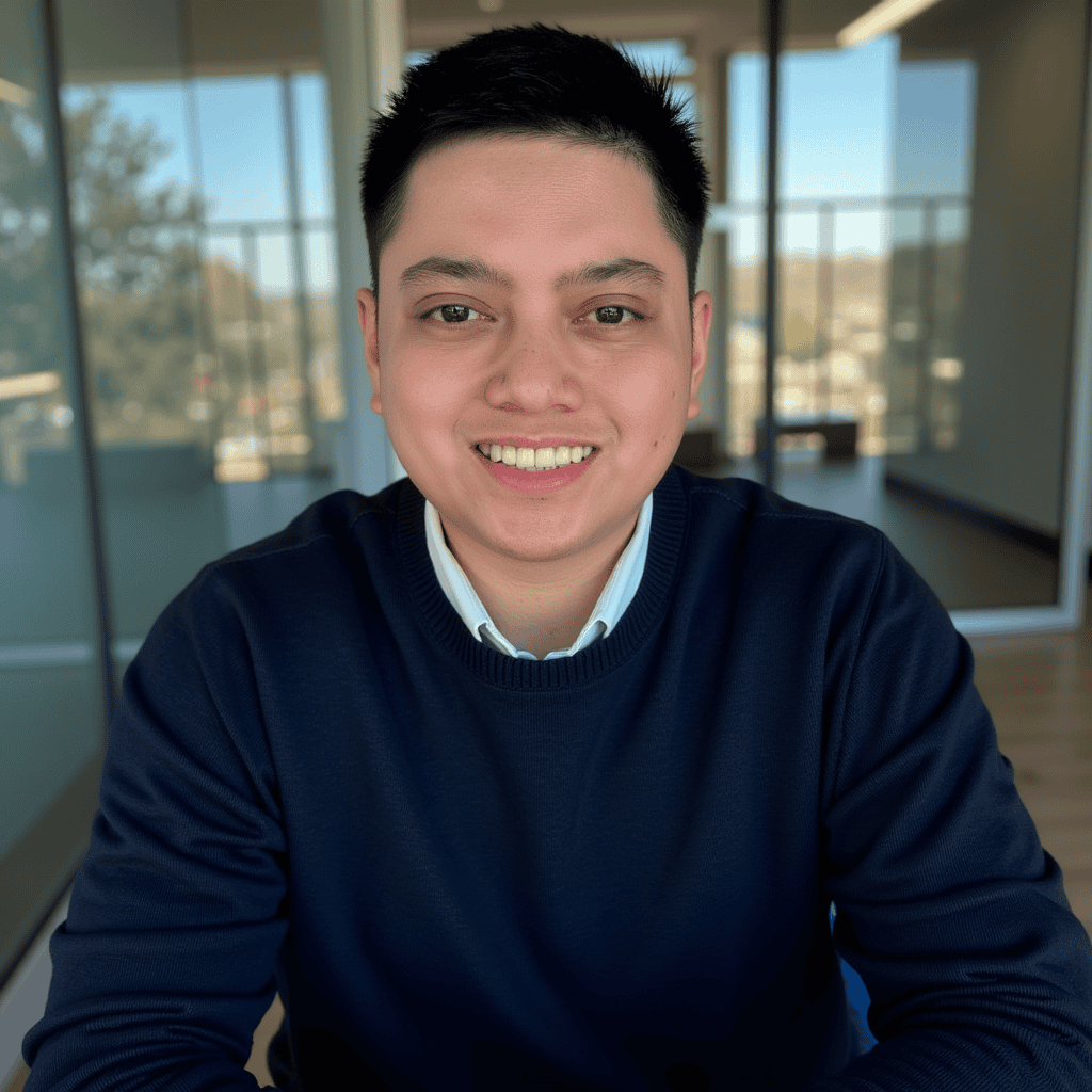 Person smiling in a bright office environment.